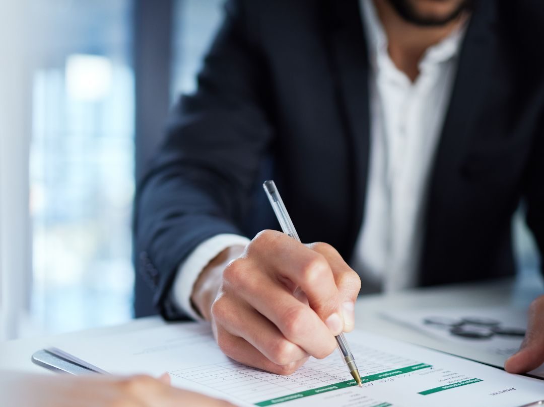 Man adding signature to paper on a clipboard. 